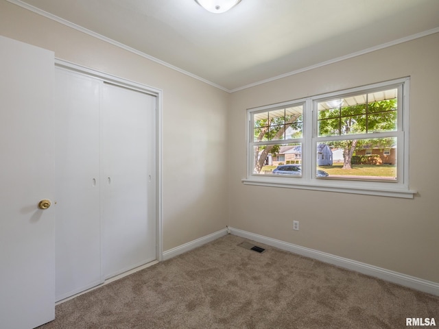 1505 N 9th St, Pekin, IL 61554 - unfurnished bedroom featuring multiple windows, carpet, ornamental molding, and a closet