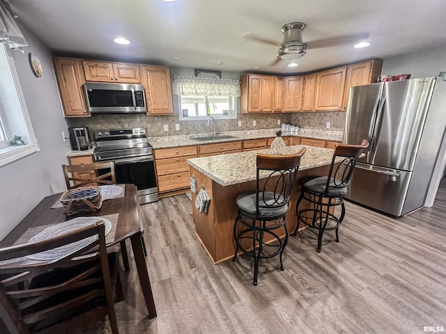 8373 State Route 93rd Rd, Toulon, IL 61483 - kitchen with stainless steel appliances, light wood-style floors, tasteful backsplash, a kitchen island, and recessed lighting