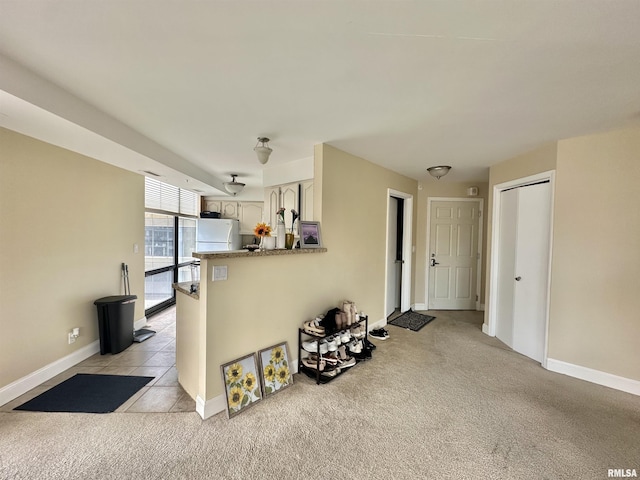 125 SW Jefferson Ave Unit W2A, Peoria, IL 61602 - kitchen with a peninsula, light colored carpet, and freestanding refrigerator
