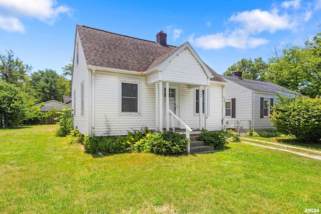 2046 W Wilson Ave, Peoria, IL 61604 - view of front of house featuring roof with shingles, a chimney, and a front yard