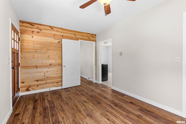 2046 W Wilson Ave, Peoria, IL 61604 - unfurnished bedroom with wooden walls, wood finished floors, and a ceiling fan