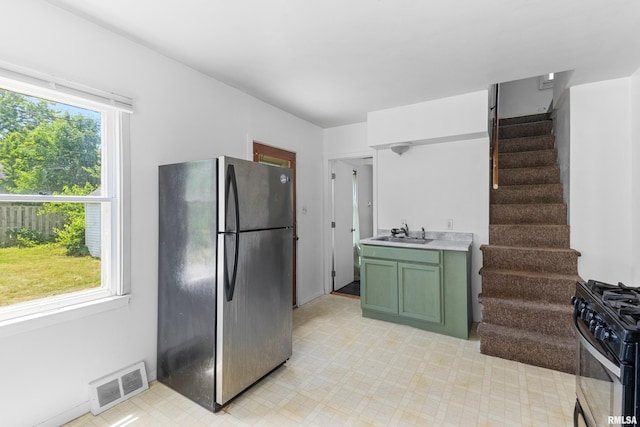 2046 W Wilson Ave, Peoria, IL 61604 - kitchen featuring freestanding refrigerator, gas stove, green cabinets, and light floors