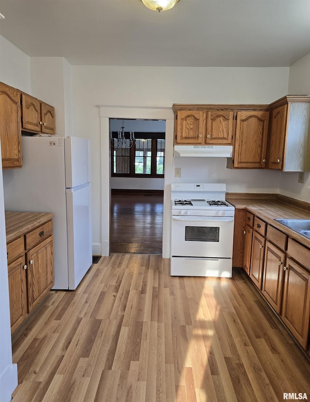 1113 S 5th St, Pekin, IL 61554 - kitchen featuring white appliances, under cabinet range hood, brown cabinets, and light wood finished floors