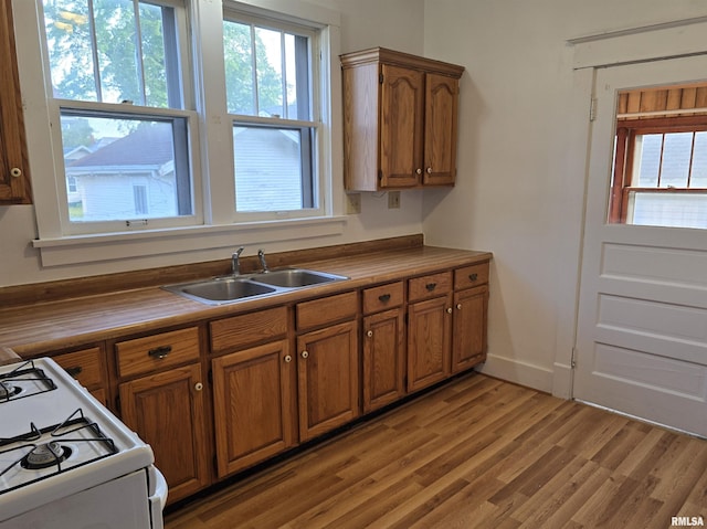 1113 S 5th St, Pekin, IL 61554 - kitchen featuring white gas range, brown cabinetry, and light wood finished floors