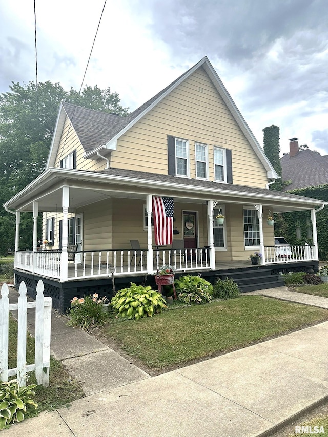 146 W Locust St, Canton, IL 61520 - farmhouse-style home featuring covered porch, a shingled roof, and a front lawn