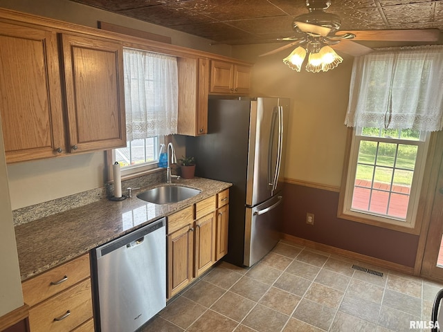 146 W Locust St, Canton, IL 61520 - kitchen with stainless steel appliances, a ceiling fan, brown cabinets, stone countertops, and an ornate ceiling