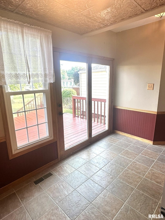 146 W Locust St, Canton, IL 61520 - doorway to outside with stone tile flooring, an ornate ceiling, and wainscoting