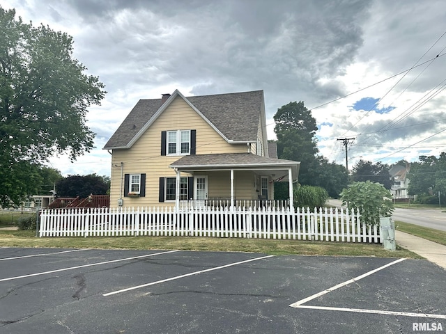 146 W Locust St, Canton, IL 61520 - view of front of property featuring a shingled roof, uncovered parking, a chimney, and a porch