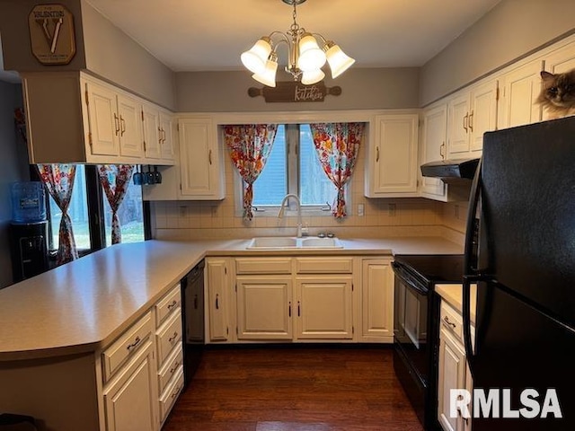 1415 E Sycamore St, Canton, IL 61520 - kitchen with black appliances, under cabinet range hood, a chandelier, and light countertops