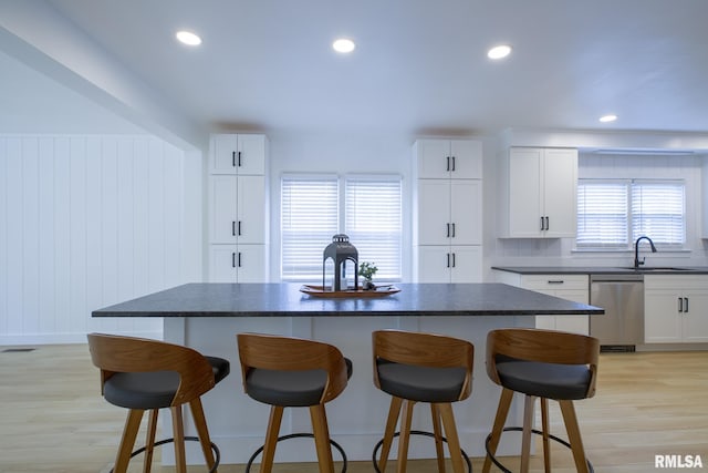 2129 Fondulac Dr, East Peoria, IL 61611 - kitchen featuring stainless steel dishwasher, dark countertops, a kitchen bar, and recessed lighting
