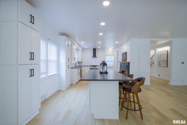 2129 Fondulac Dr, East Peoria, IL 61611 - kitchen with dark countertops, a kitchen island, plenty of natural light, a breakfast bar area, and recessed lighting