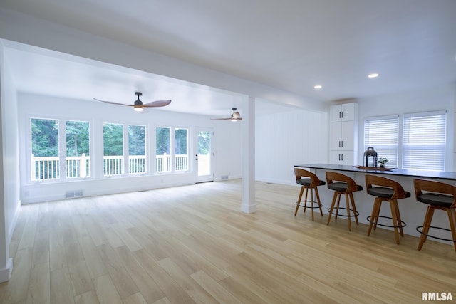 2129 Fondulac Dr, East Peoria, IL 61611 - kitchen featuring light wood-style flooring, white cabinets, a kitchen bar, recessed lighting, and a ceiling fan