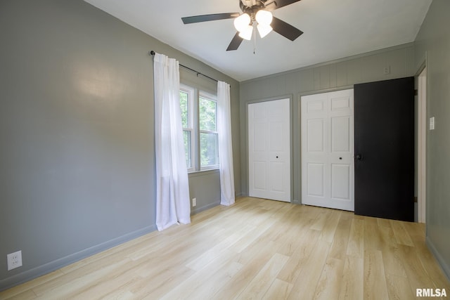 2129 Fondulac Dr, East Peoria, IL 61611 - unfurnished bedroom featuring light wood finished floors, a ceiling fan, and multiple closets