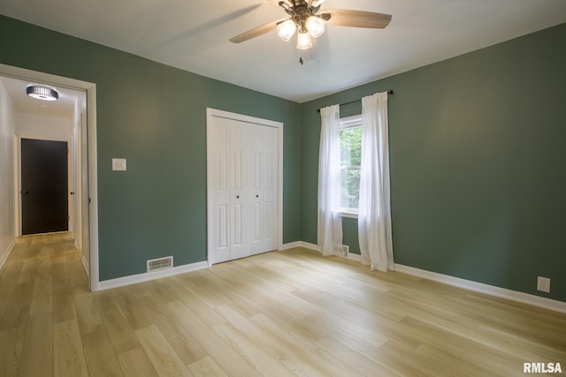 2129 Fondulac Dr, East Peoria, IL 61611 - unfurnished bedroom with light wood-style flooring, a closet, and a ceiling fan