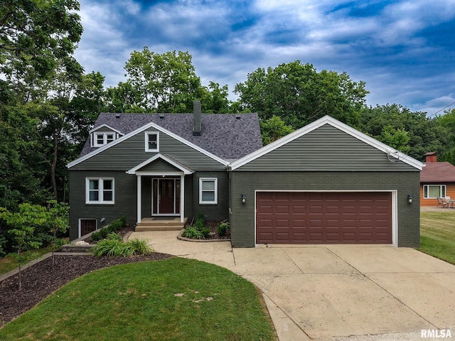 2129 Fondulac Dr, East Peoria, IL 61611 - view of front facade with brick siding, a front yard, a garage, and driveway