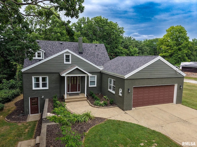 2129 Fondulac Dr, East Peoria, IL 61611 - traditional-style home featuring an attached garage, roof with shingles, brick siding, and concrete driveway