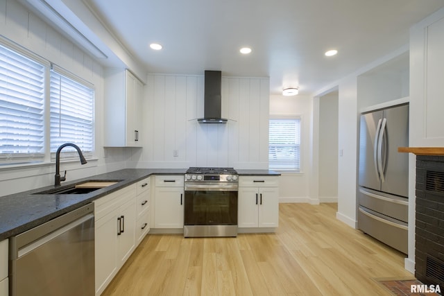 2129 Fondulac Dr, East Peoria, IL 61611 - kitchen with appliances with stainless steel finishes, wall chimney range hood, light wood-type flooring, white cabinets, and recessed lighting