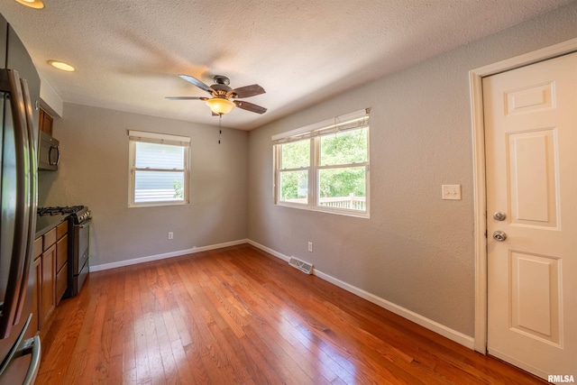 6822 N Kimberly Dr, Peoria, IL 61614 - unfurnished living room featuring light wood-type flooring, a textured ceiling, and a ceiling fan