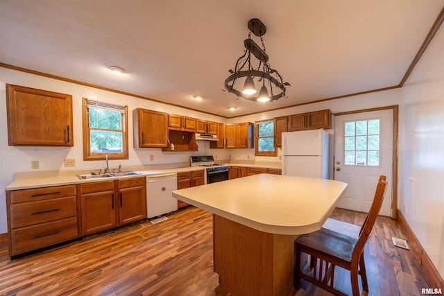 1025 E Maywood Ave, Peoria, IL 61603 - kitchen featuring white appliances, dark wood-type flooring, crown molding, under cabinet range hood, and a kitchen breakfast bar