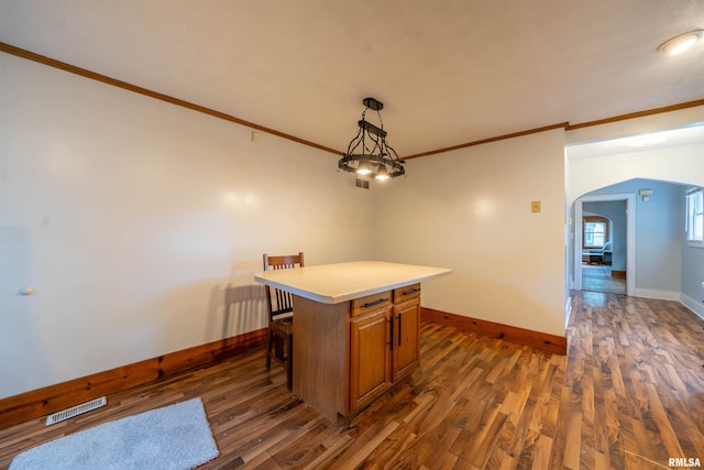 1025 E Maywood Ave, Peoria, IL 61603 - kitchen with arched walkways, ornamental molding, brown cabinets, dark wood finished floors, and light countertops
