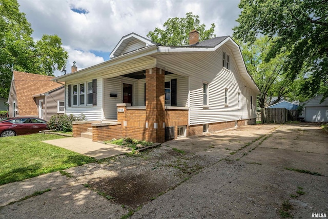 1025 E Maywood Ave, Peoria, IL 61603 - view of front facade with a chimney, asphalt driveway, and covered porch
