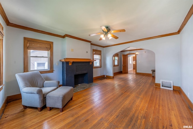 1025 E Maywood Ave, Peoria, IL 61603 - living area with arched walkways, wood finished floors, ornamental molding, a fireplace, and ceiling fan