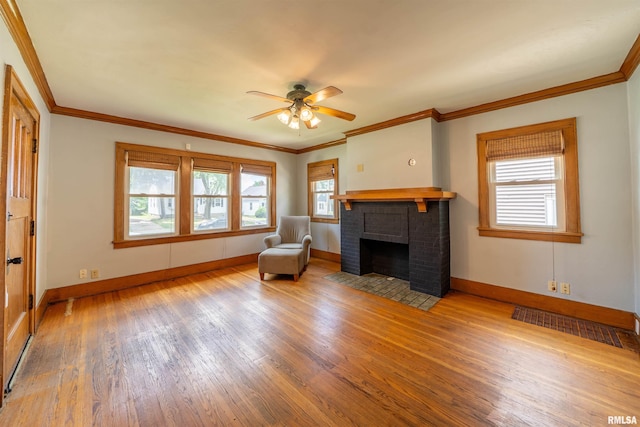 1025 E Maywood Ave, Peoria, IL 61603 - unfurnished living room featuring wood finished floors, ceiling fan, a brick fireplace, and crown molding