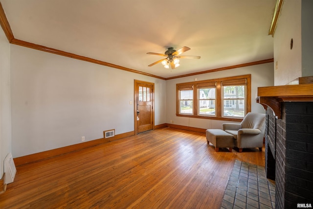 1025 E Maywood Ave, Peoria, IL 61603 - sitting room featuring wood finished floors, a brick fireplace, a ceiling fan, and ornamental molding
