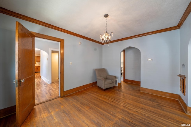 1025 E Maywood Ave, Peoria, IL 61603 - unfurnished room with arched walkways, wood finished floors, ornamental molding, and a chandelier