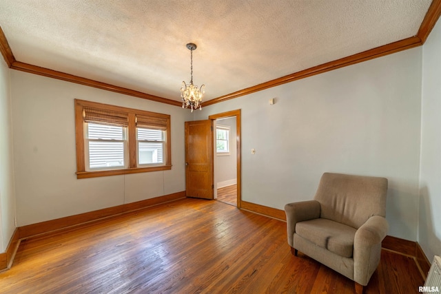 1025 E Maywood Ave, Peoria, IL 61603 - living area featuring ornamental molding, a chandelier, a textured ceiling, and wood finished floors