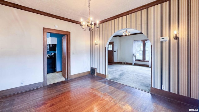 1113 N Summit Blvd, Peoria, IL 61606 - spare room featuring arched walkways, crown molding, wood finished floors, and a chandelier