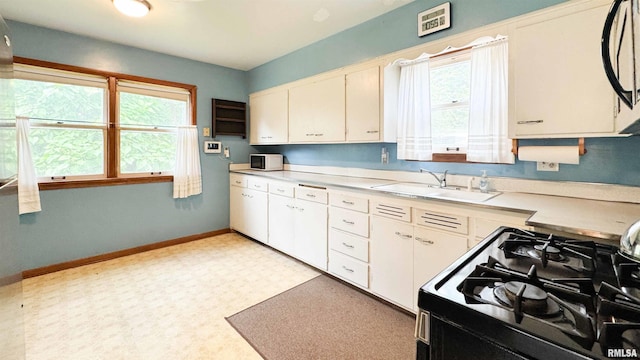 1113 N Summit Blvd, Peoria, IL 61606 - kitchen with gas range oven, light countertops, white cabinets, white microwave, and light flooring
