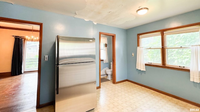 1113 N Summit Blvd, Peoria, IL 61606 - kitchen with freestanding refrigerator, a chandelier, and tile patterned floors