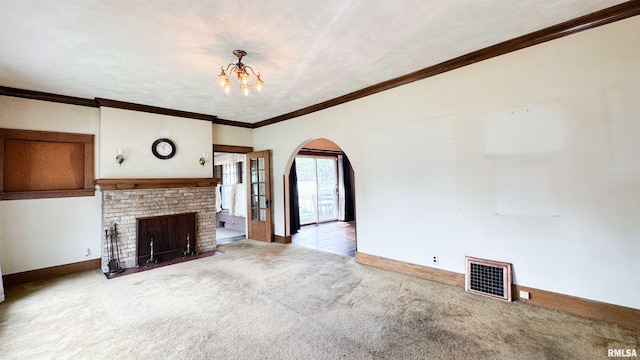 1113 N Summit Blvd, Peoria, IL 61606 - unfurnished living room featuring arched walkways, carpet floors, a chandelier, a brick fireplace, and crown molding