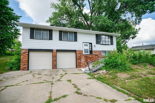 2705 W Millbrook Ct, Peoria, IL 61615 - raised ranch featuring brick siding, a garage, and concrete driveway