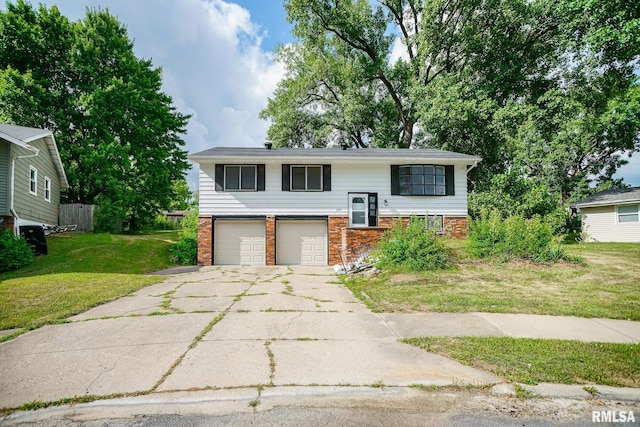 2705 W Millbrook Ct, Peoria, IL 61615 - raised ranch featuring brick siding, a garage, concrete driveway, and a front lawn
