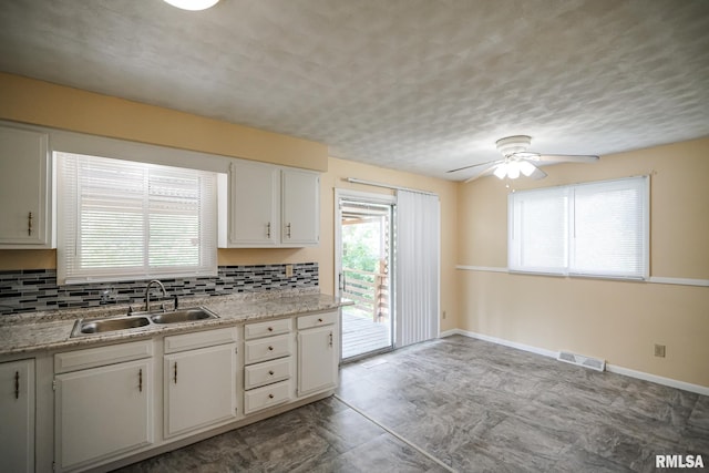 2705 W Millbrook Ct, Peoria, IL 61615 - kitchen with ceiling fan, backsplash, light countertops, white cabinetry, and a textured ceiling