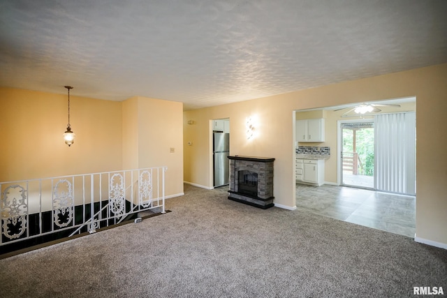 2705 W Millbrook Ct, Peoria, IL 61615 - living room featuring light colored carpet, a fireplace, ceiling fan, and a textured ceiling