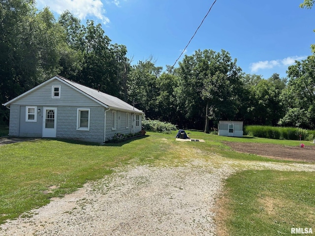 728 Hanna Dr, Pekin, IL 61554 - view of home's exterior featuring a yard, driveway, and a storage unit