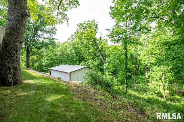 1701 Woodland Knolls Rd, Metamora, IL 61548 - view of green lawn featuring an outdoor structure, a pole building, and a wooded view