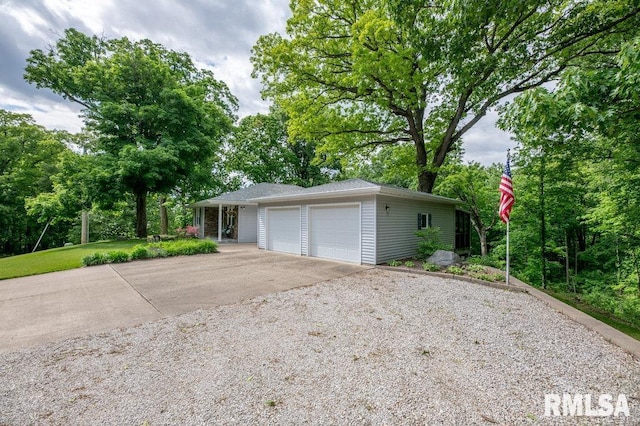 1701 Woodland Knolls Rd, Metamora, IL 61548 - garage with concrete driveway and view of scattered trees