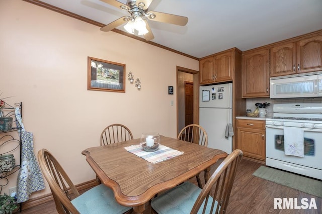 1701 Woodland Knolls Rd, Metamora, IL 61548 - kitchen featuring white appliances, dark wood-type flooring, a ceiling fan, brown cabinetry, and ornamental molding