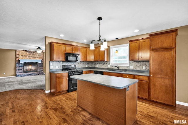 1129 Stonelake Ct, Metamora, IL 61548 - kitchen with black appliances, dark wood finished floors, brown cabinetry, open floor plan, and a fireplace