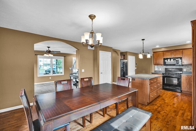 1129 Stonelake Ct, Metamora, IL 61548 - dining space featuring arched walkways, a chandelier, dark wood-type flooring, a ceiling fan, and recessed lighting
