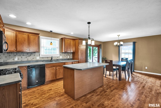 1129 Stonelake Ct, Metamora, IL 61548 - kitchen with dishwasher, dark wood-style floors, backsplash, a chandelier, and a center island