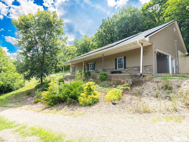 797 State Route 29th Hwy, Sparland, IL 61565 - view of front facade with a garage, covered porch, stone siding, and view of wooded area
