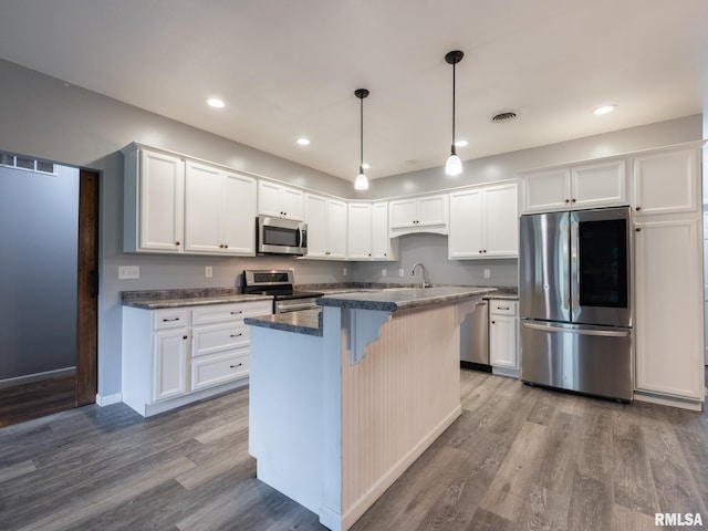 797 State Route 29th Hwy, Sparland, IL 61565 - kitchen featuring appliances with stainless steel finishes, white cabinetry, dark wood-style flooring, a kitchen island, and recessed lighting