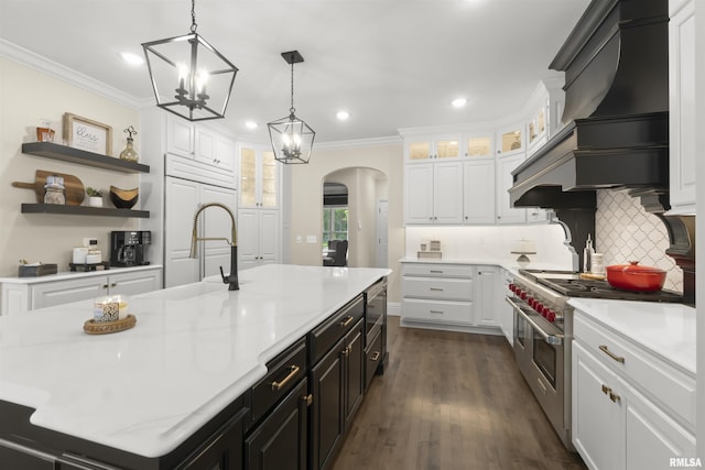 2815 W Windpointe Dr, Peoria, IL 61614 - kitchen featuring range with two ovens, arched walkways, light countertops, white cabinets, and ornamental molding
