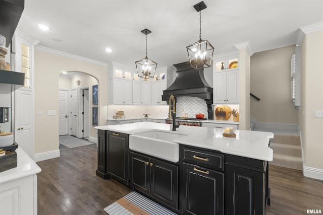 2815 W Windpointe Dr, Peoria, IL 61614 - kitchen featuring dark cabinetry, white cabinetry, wall chimney range hood, light countertops, and backsplash