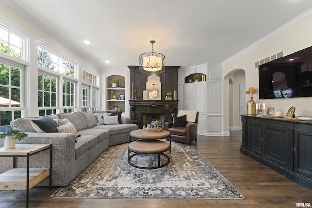 2815 W Windpointe Dr, Peoria, IL 61614 - living area with arched walkways, ornamental molding, dark wood-style floors, built in features, and a high end fireplace